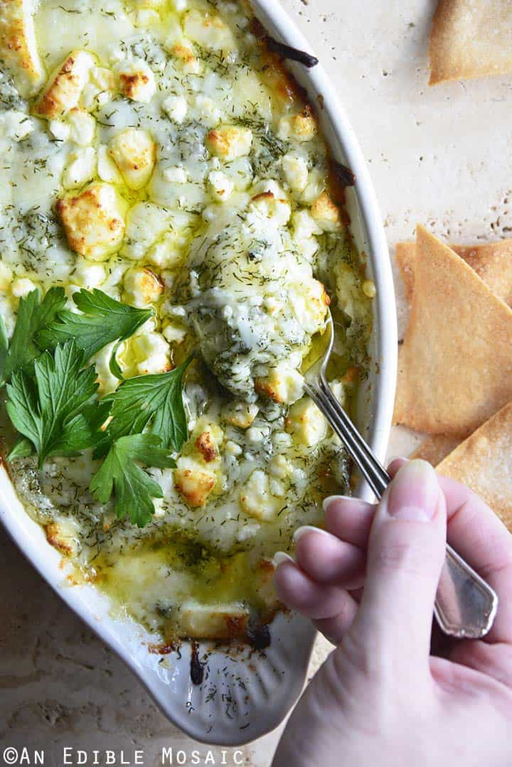 Keto Spanakopita Dip with Hand Holding Spoon in Dip