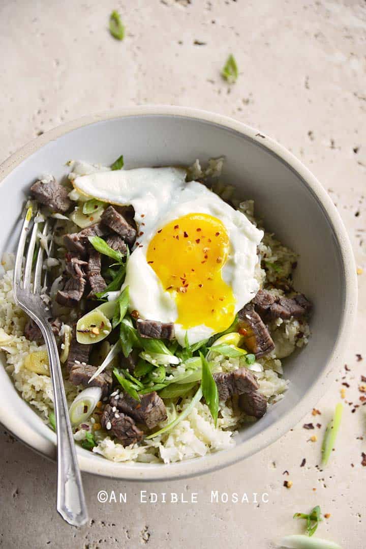 Overhead View of Low Carb Chili Garlic Steak Rice Bowl with Fried Egg and Runny Yolk