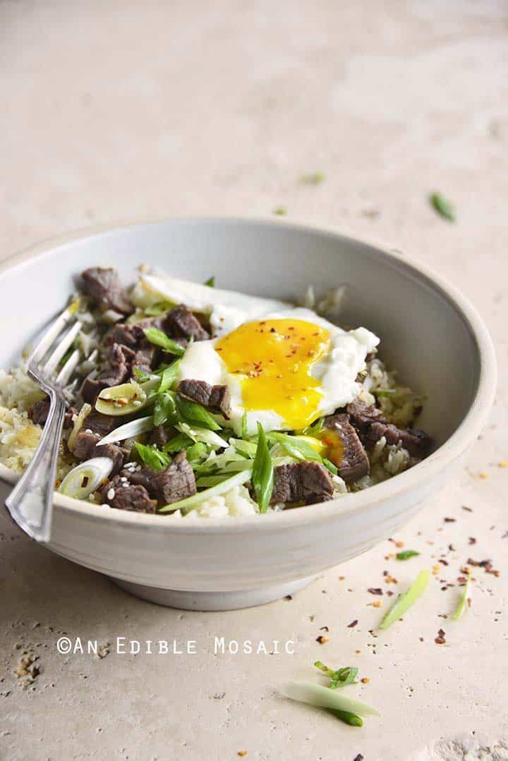 Bowl of Low Carb Chili Garlic Steak Rice on Creamy Marble Background