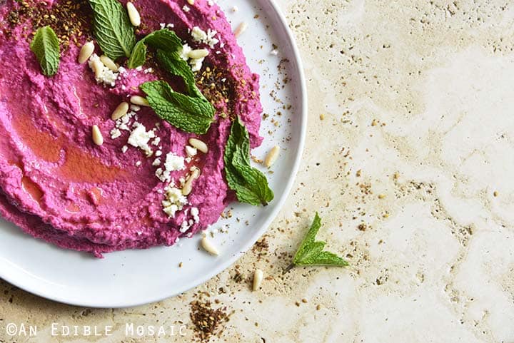 Close Up of Pickled Beet Hummus on White Plate on Creamy Colored Marble