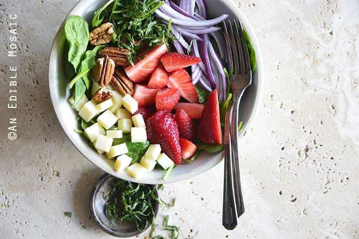 Close Up of Spinach Strawberry Salad with Small Dish of Mint