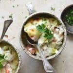 Close Up Overhead View of Creamy Chicken Casserole with Cheesy Cauliflower Mash in Ceramic Mugs on Creamy Background