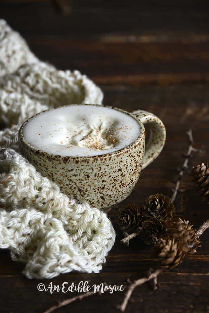 Front View of Eggnog Latte in Ceramic Mug with Cream Colored Scarf