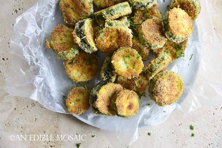Top View of Keto Crispy Baked Zucchini Slices on White Plate with Wax Paper