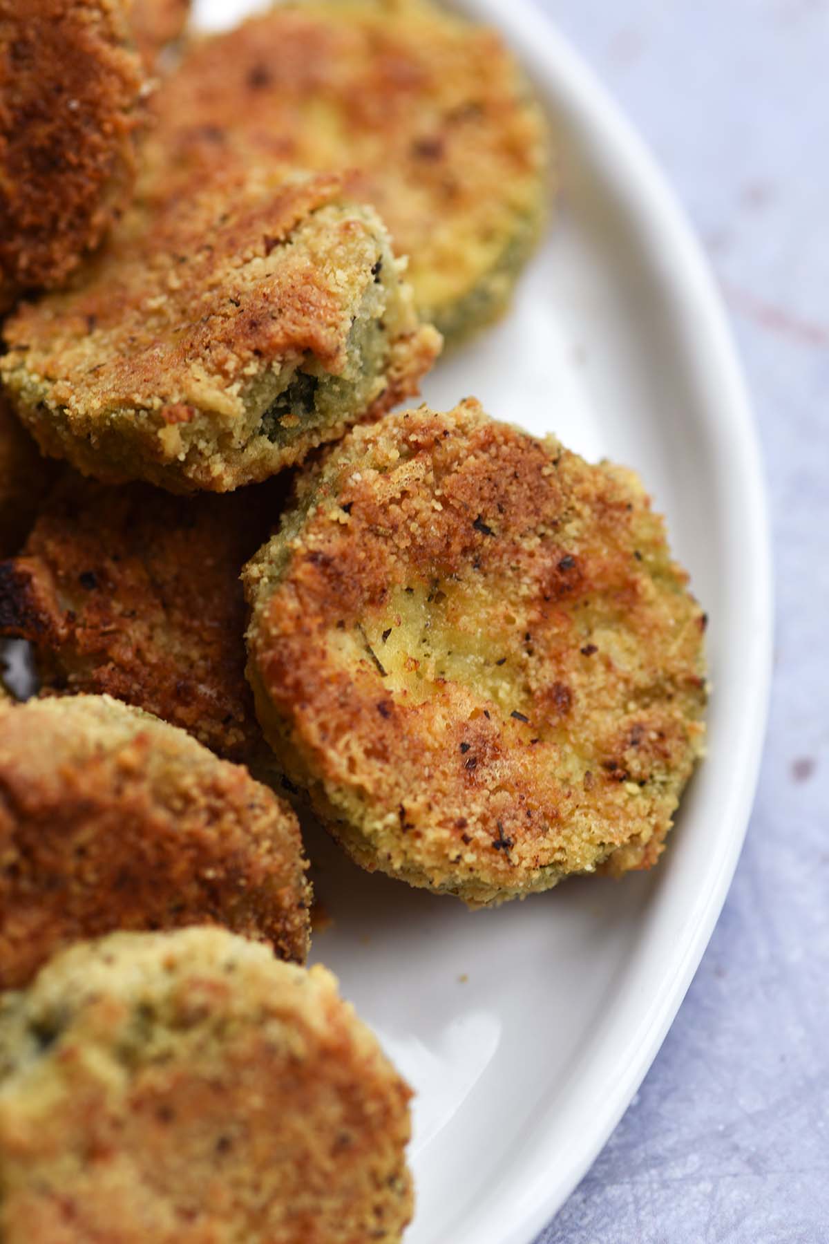 close up of low carb baked zucchini slices showing crispy coating