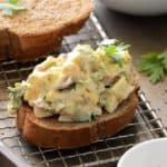 Assembling Egg Salad with Bacon and Creamy Honey Mustard Dressing Into a Sandwich