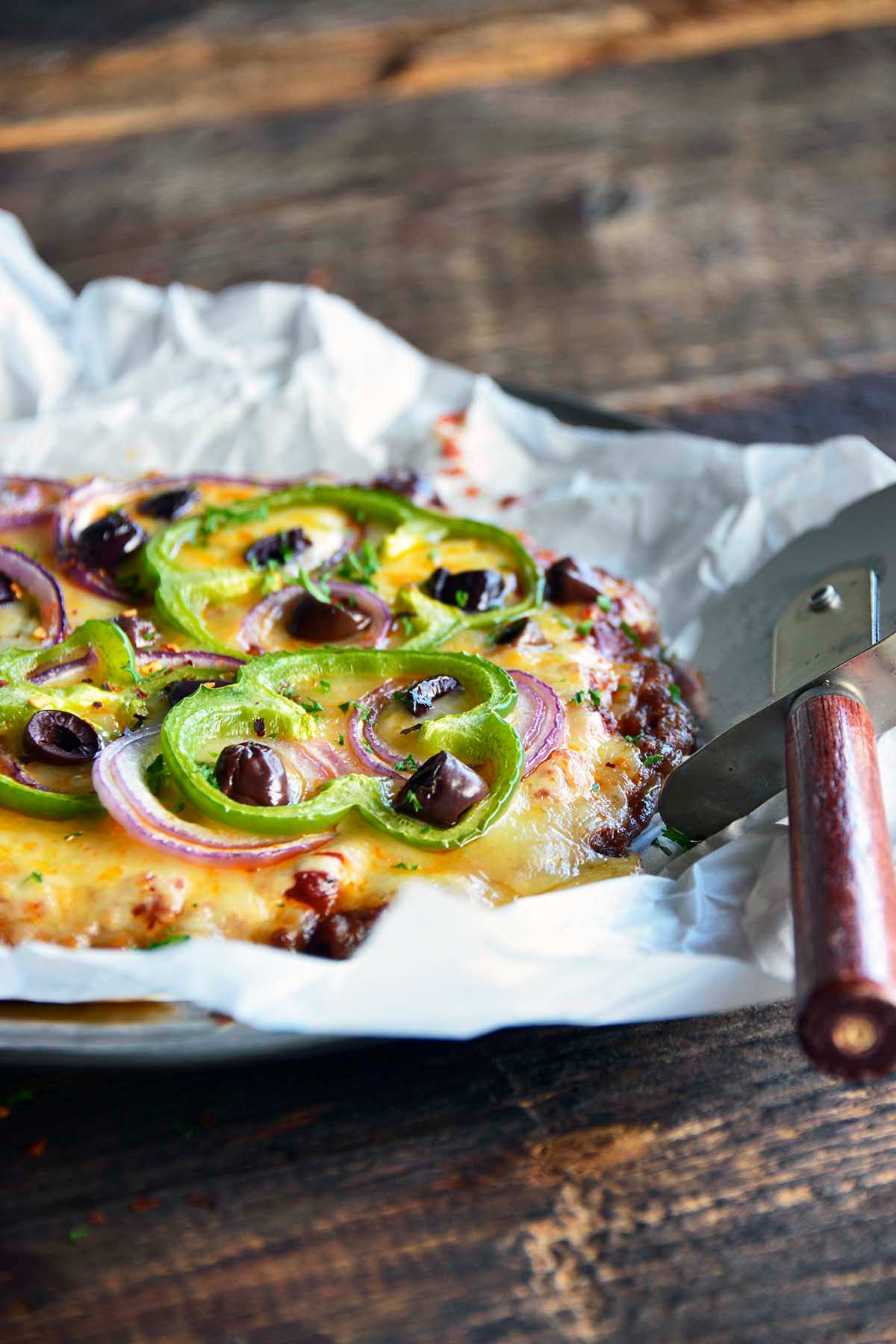 front view of Italian sausage meatza with peppers and olives