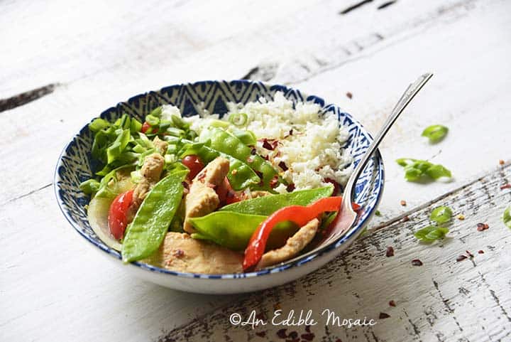 Front View of a Bowl of Healthy Sweet and Sour Chicken Stir Fry on White Wooden Table