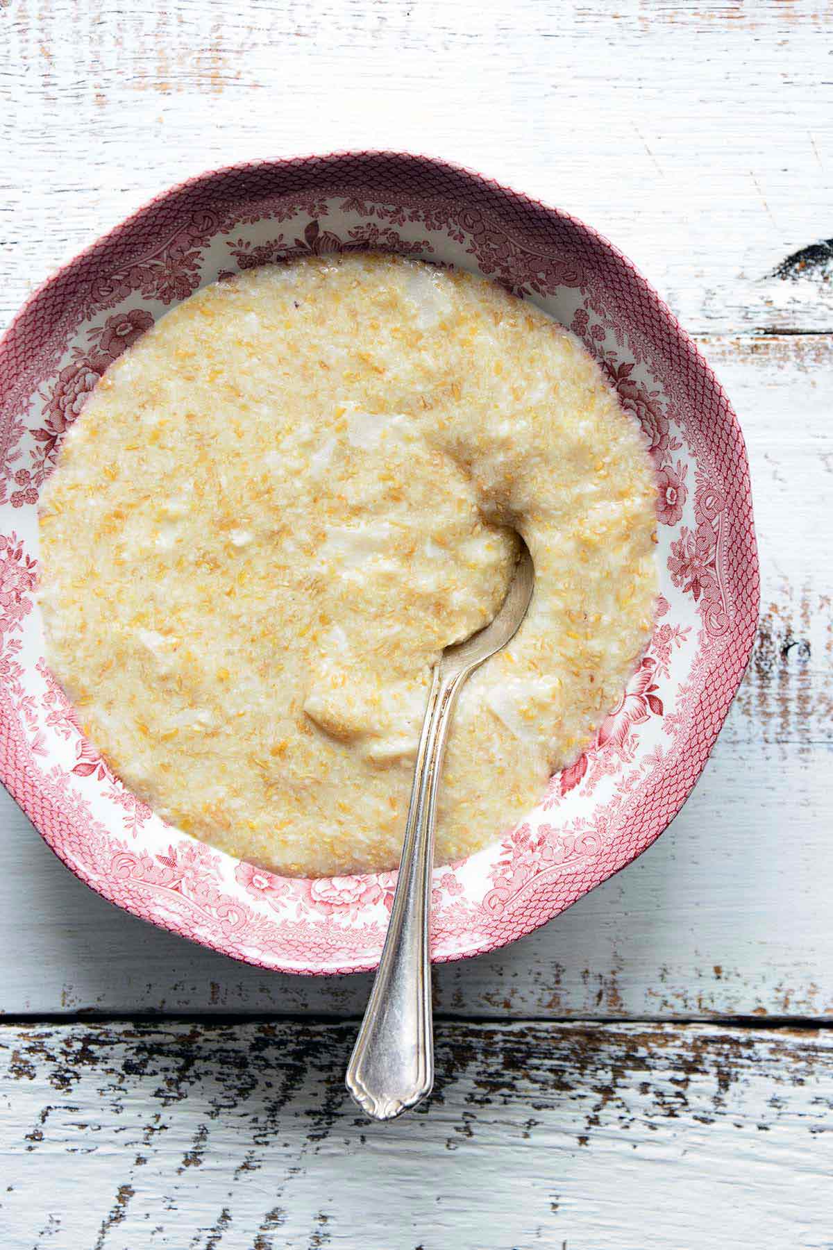 bowl of keto hot cereal or oats alternative with coconut on white wooden table