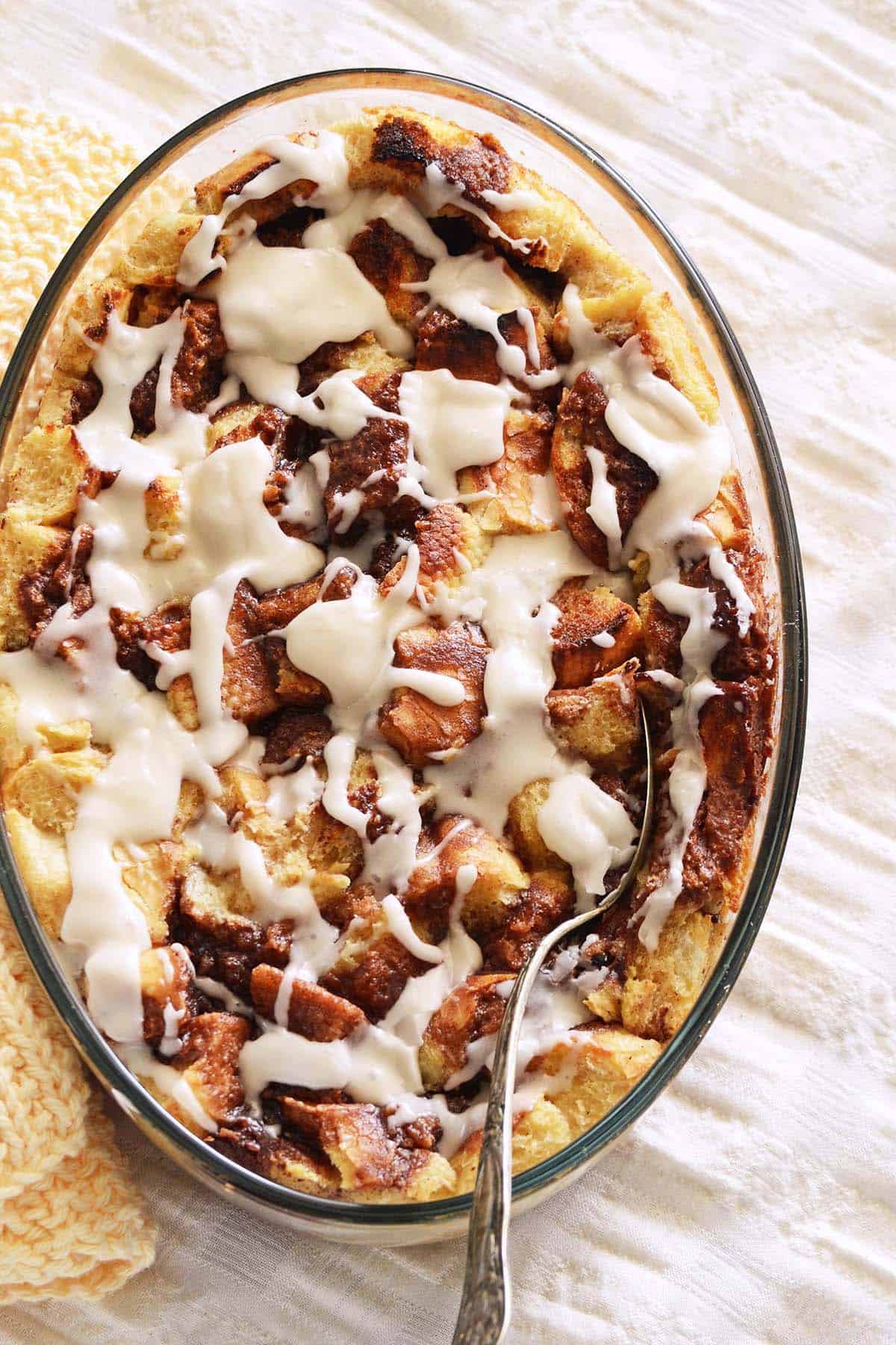 close up top view of overnight bread pudding recipe with cinnamon sugar and vanilla glaze