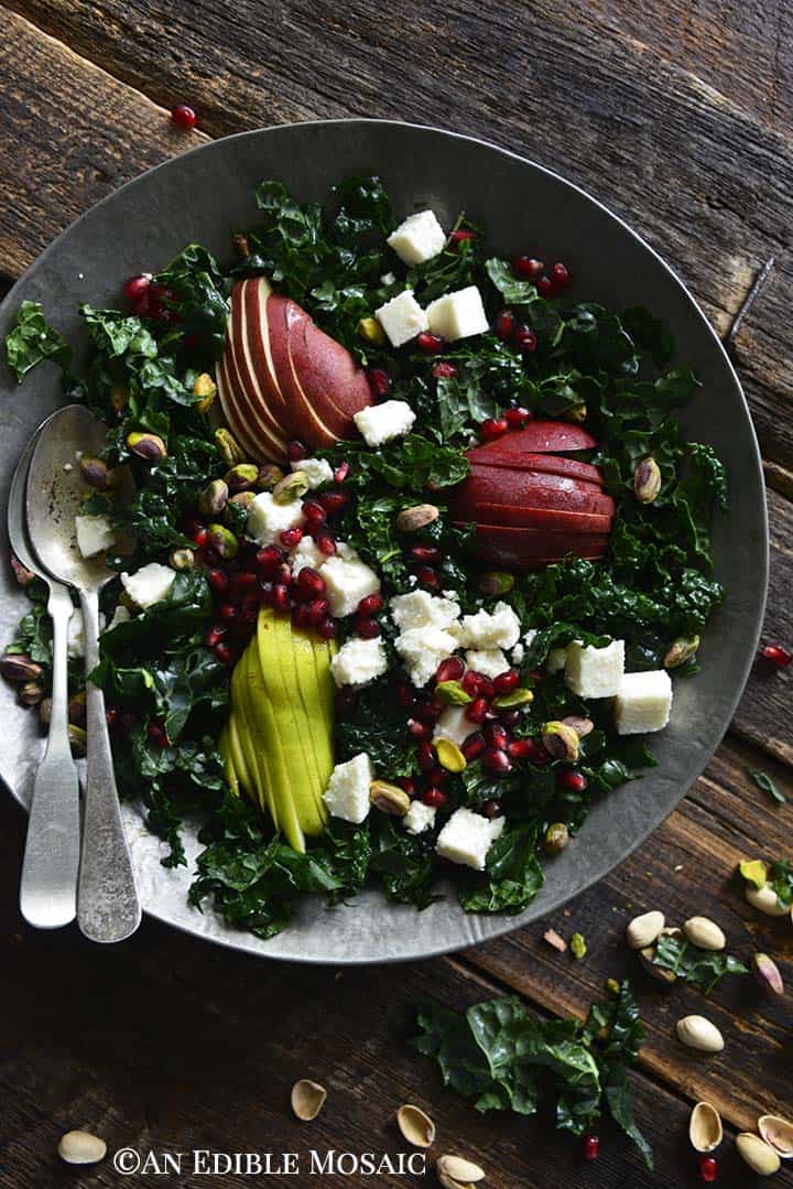 Close Up Overhead View of Winter Salad with Kale and Pomegranate on Wooden Table