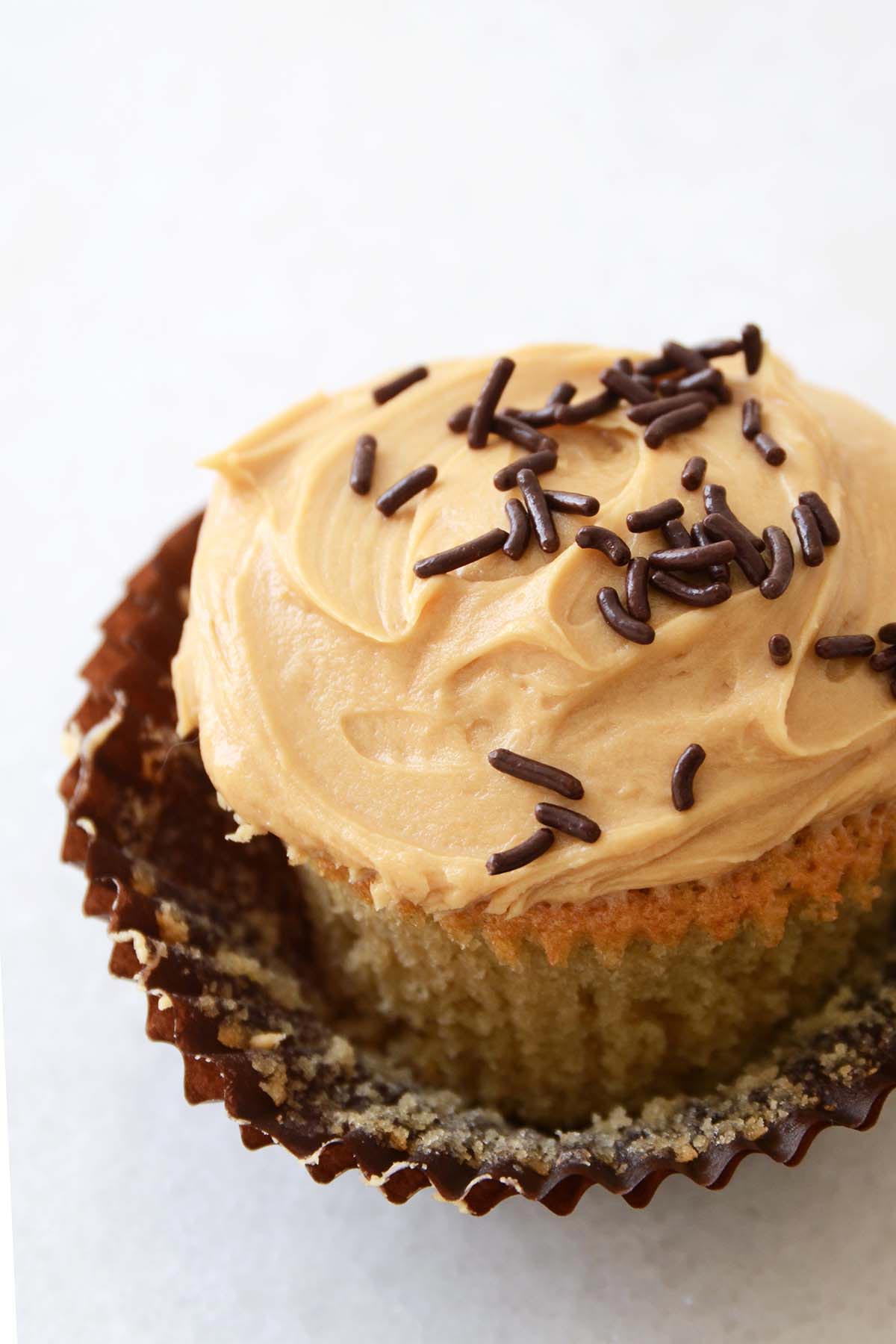 close up of vanilla guinness cupcake with salted caramel coffee frosting and chocolate sprinkles