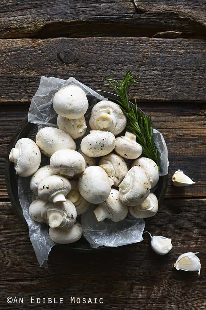 Raw Button Mushrooms on Dark Wooden Table