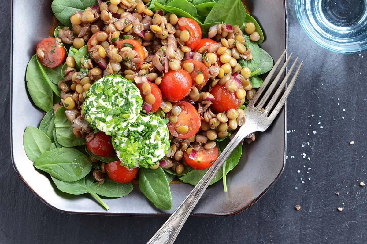 herbed goat cheese lentil salad in dish on slate