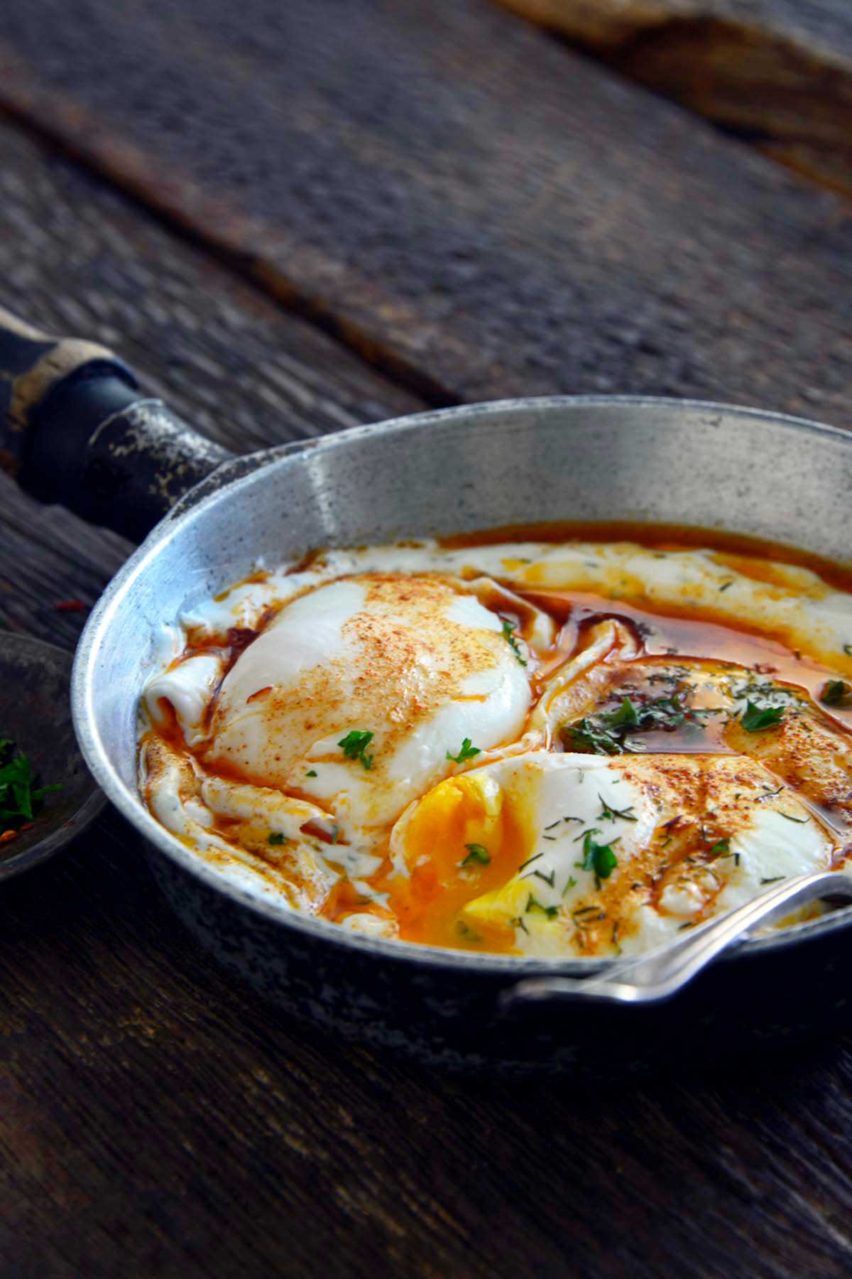 front view of Cilbir showing poached eggs with runny yolk