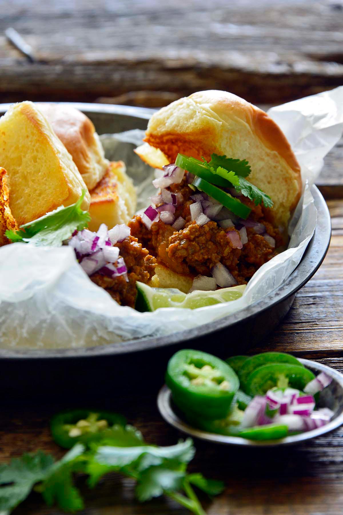 front view of street food style Indian sloppy Joe sliders with fresh toppings