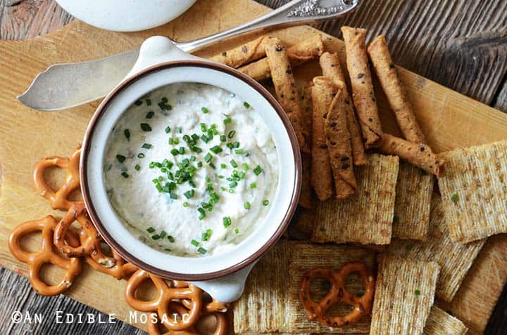 Garlic and Chive Cottage Cheese Dip with Assorted Chips for Dipping on Wooden Board