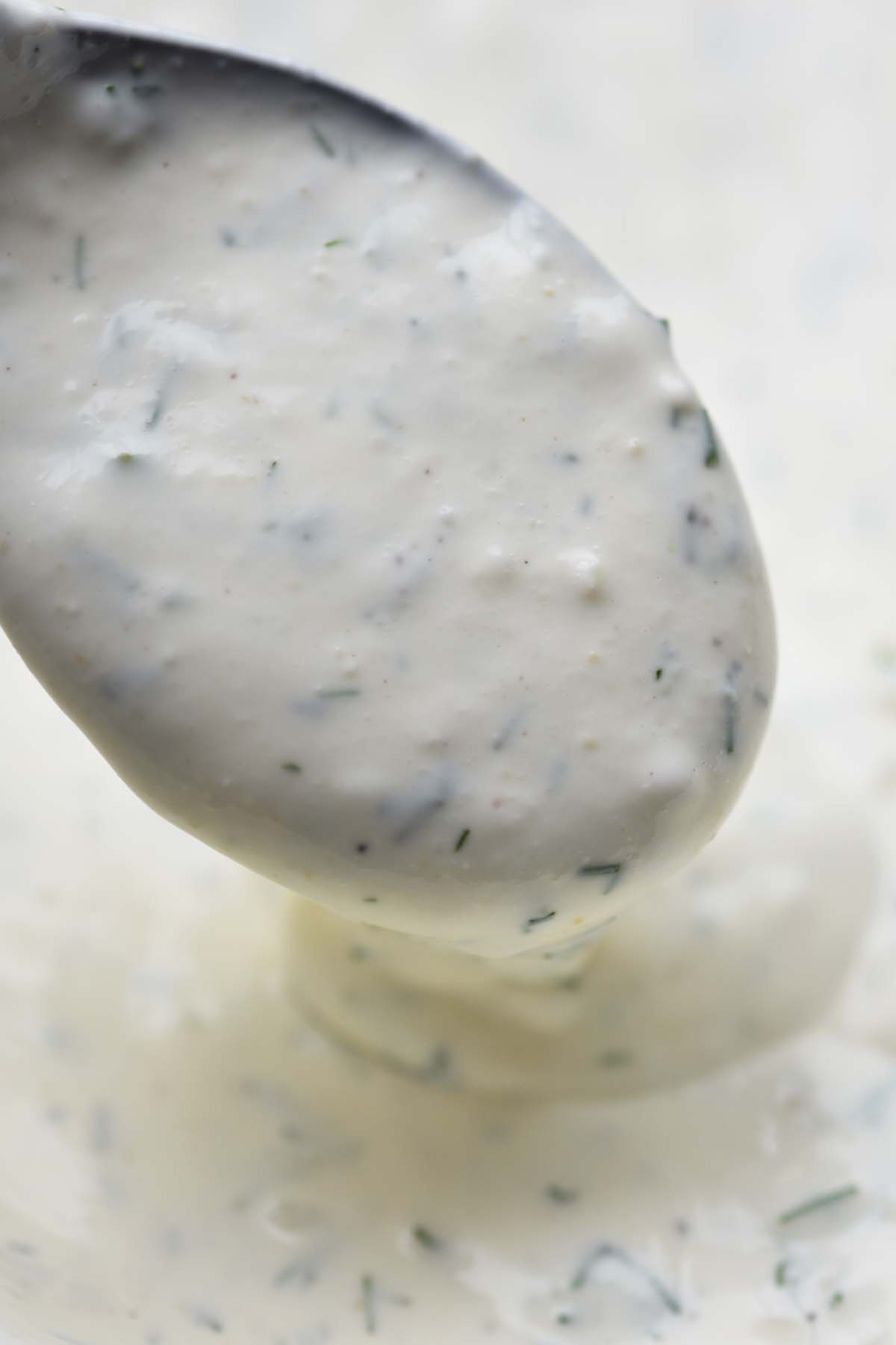 close up of spoonful of homemade ranch dressing to show thick creamy texture