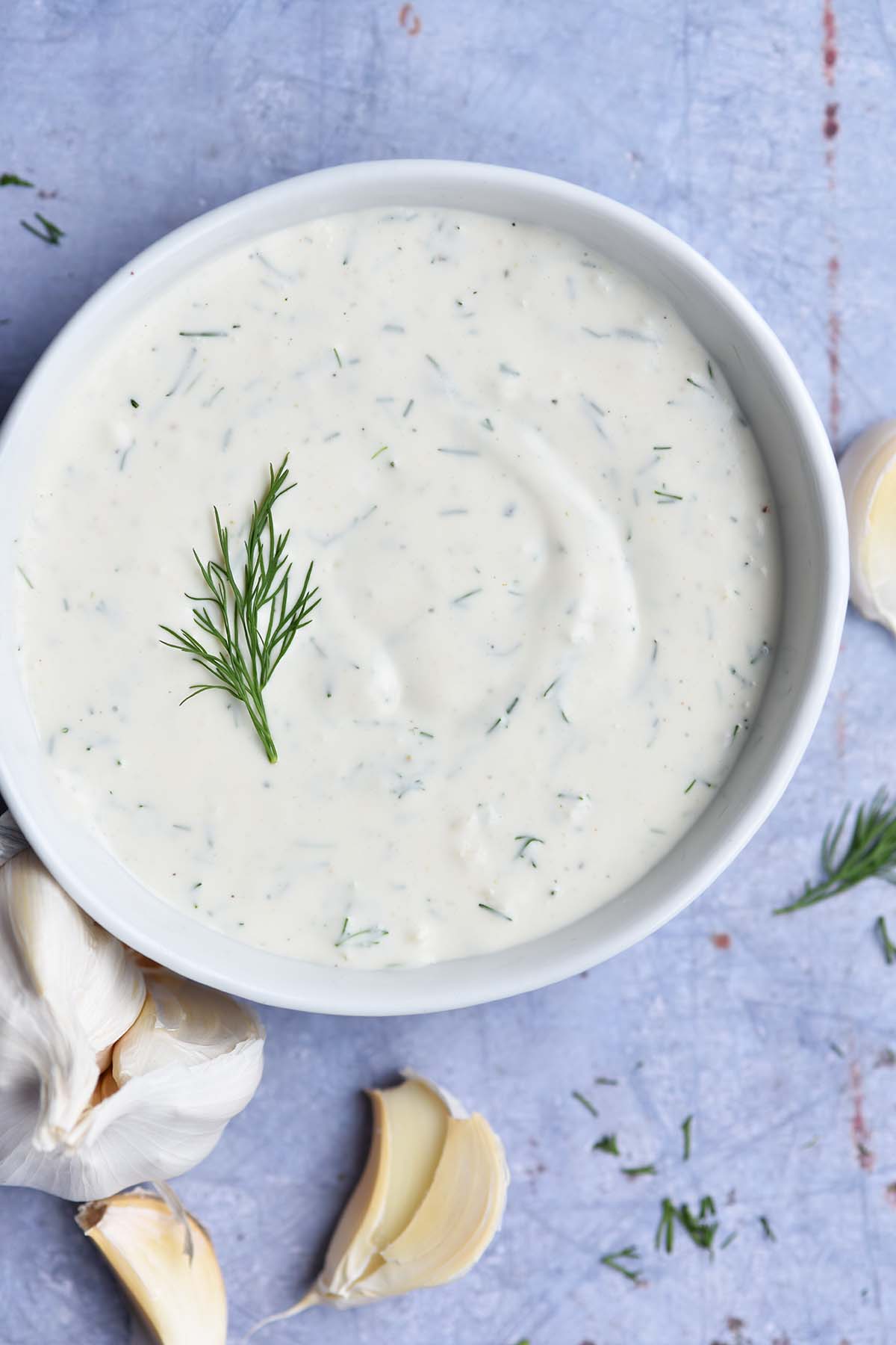 close up top view of bowl of ranch dressing on blue countertop