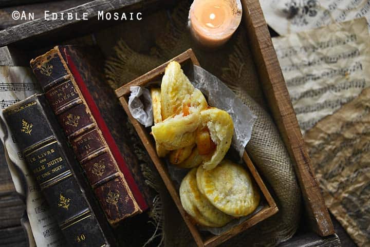 Peach Hand Pies in Dark Wooden Box with Old Books and Candle