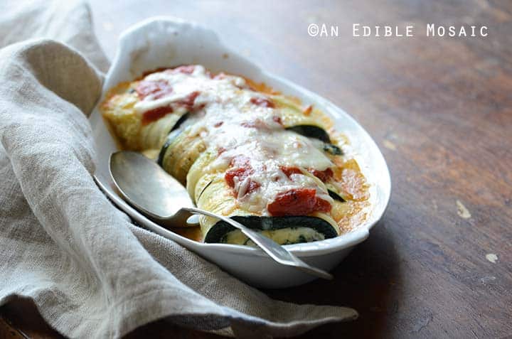 Zucchini Rollatini in White Gratin Dish Next to Linen