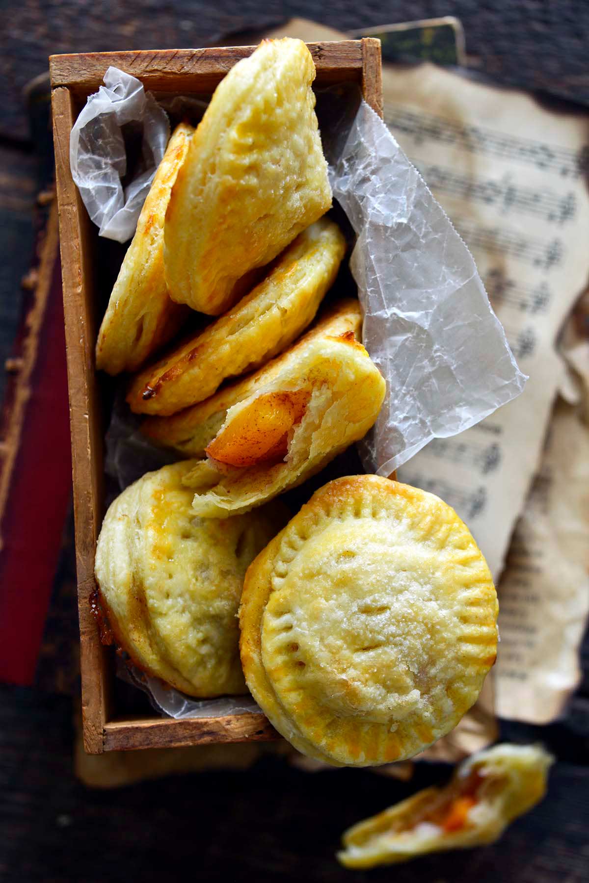 flaky hand pies with fresh peach filling in vintage wooden crate