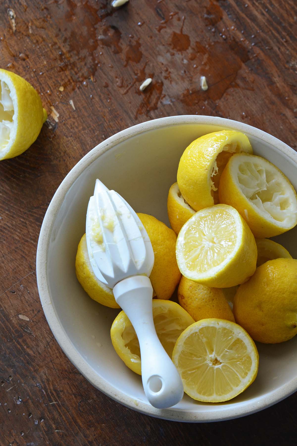 white bowl with lemons on wooden table