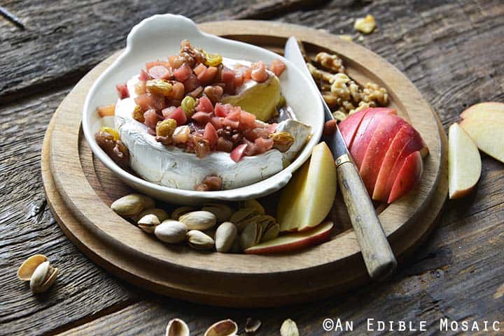 Apple Baked Brie Recipe on Wooden Tray with Apple Slices and Nuts