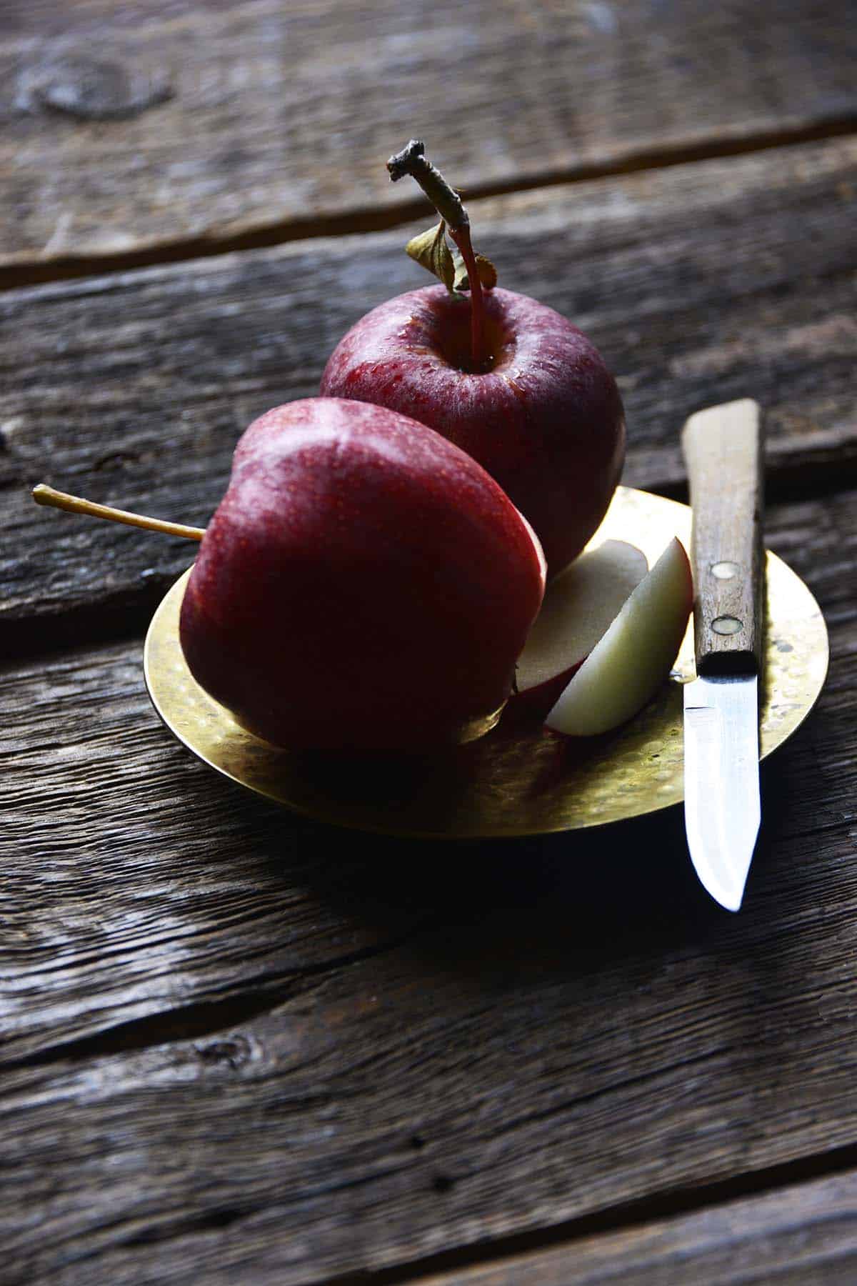 apples on small brass plate with paring knife