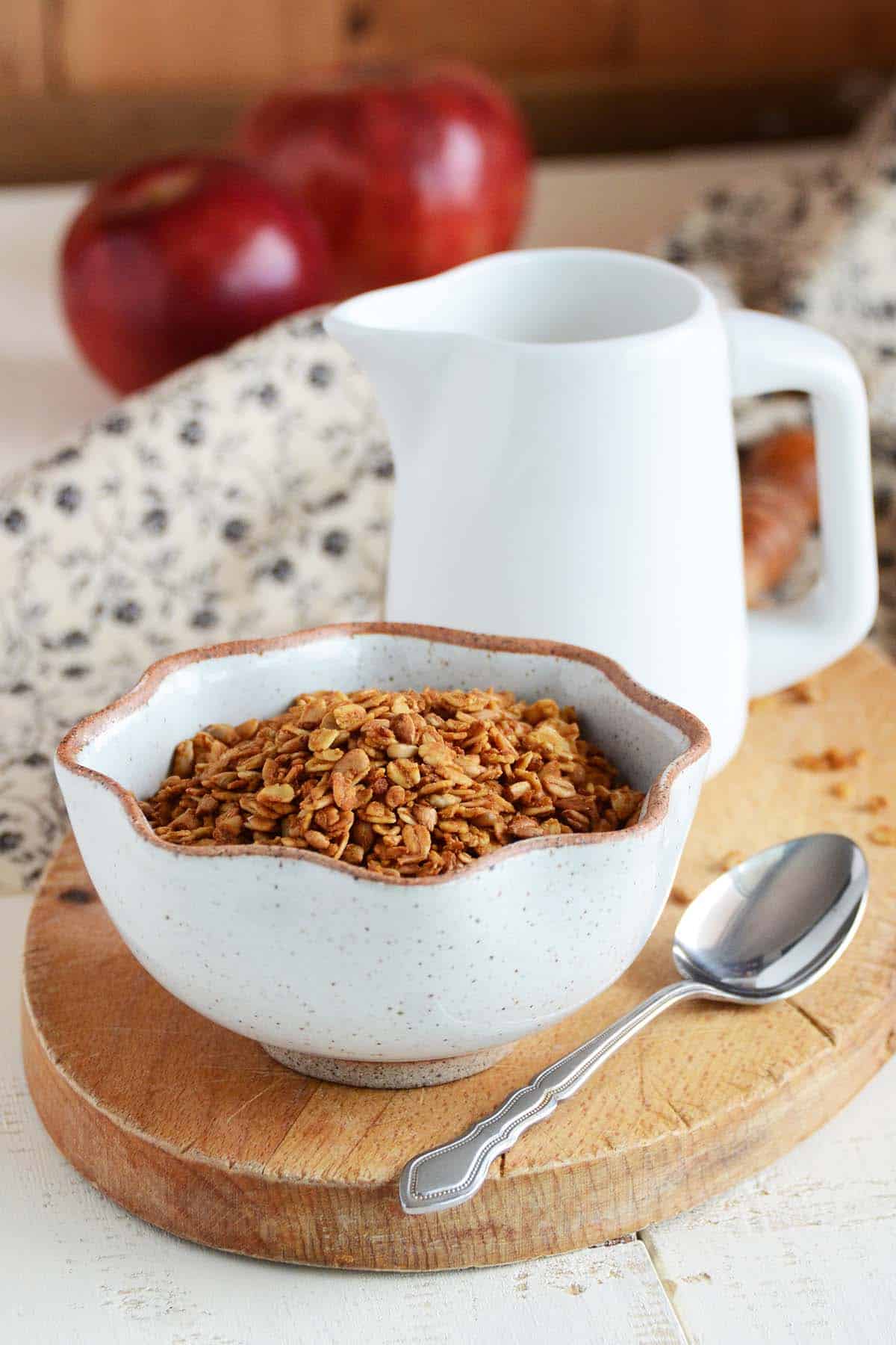 bowl of pumpkin spice granola with jug of milk