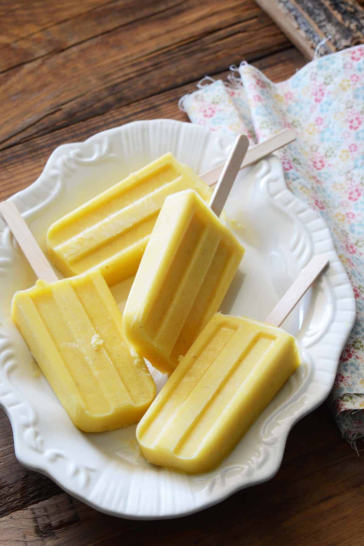 vanilla pineapple popsicles on white tray on wooden table