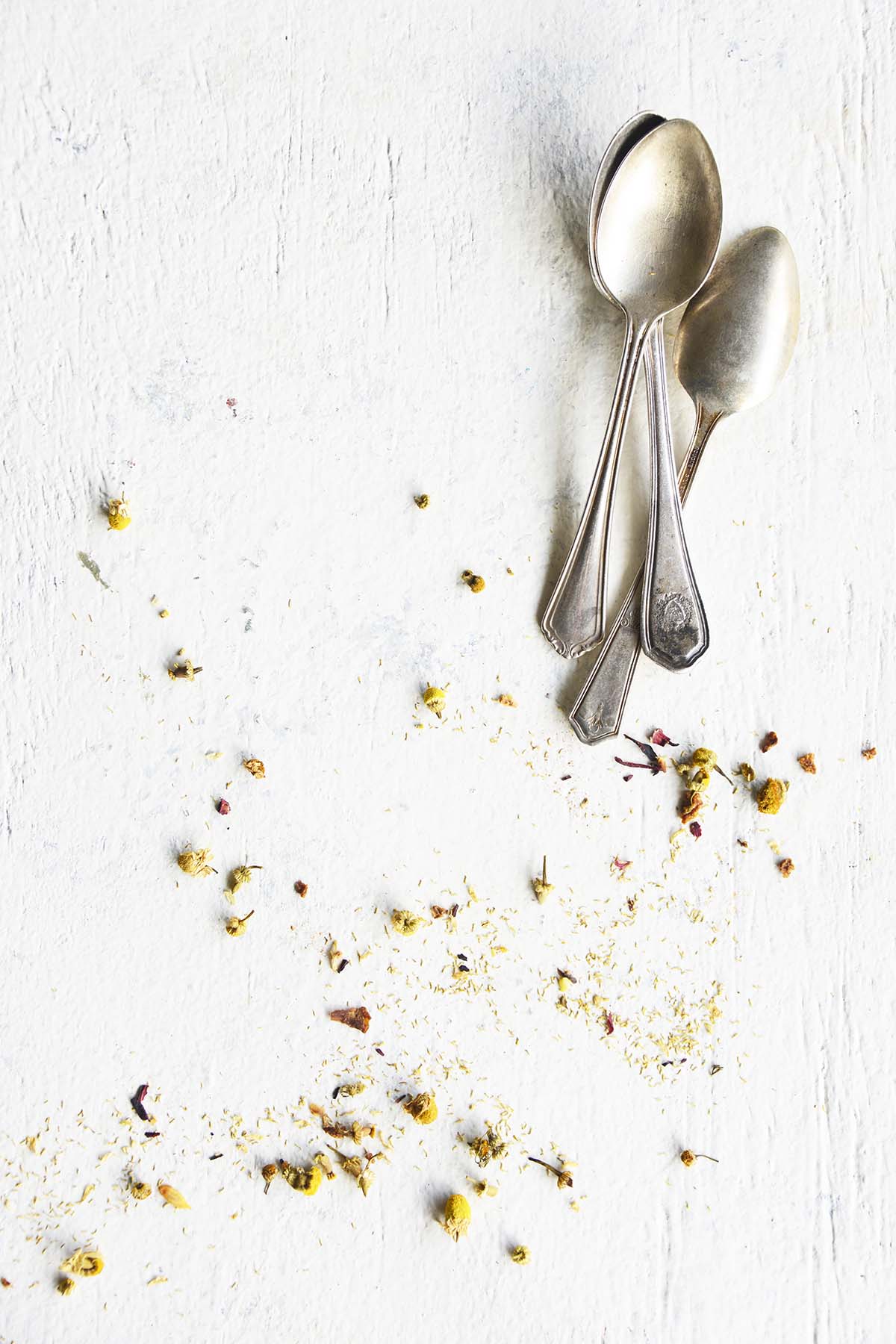 chamomile and vintage spoons on white table