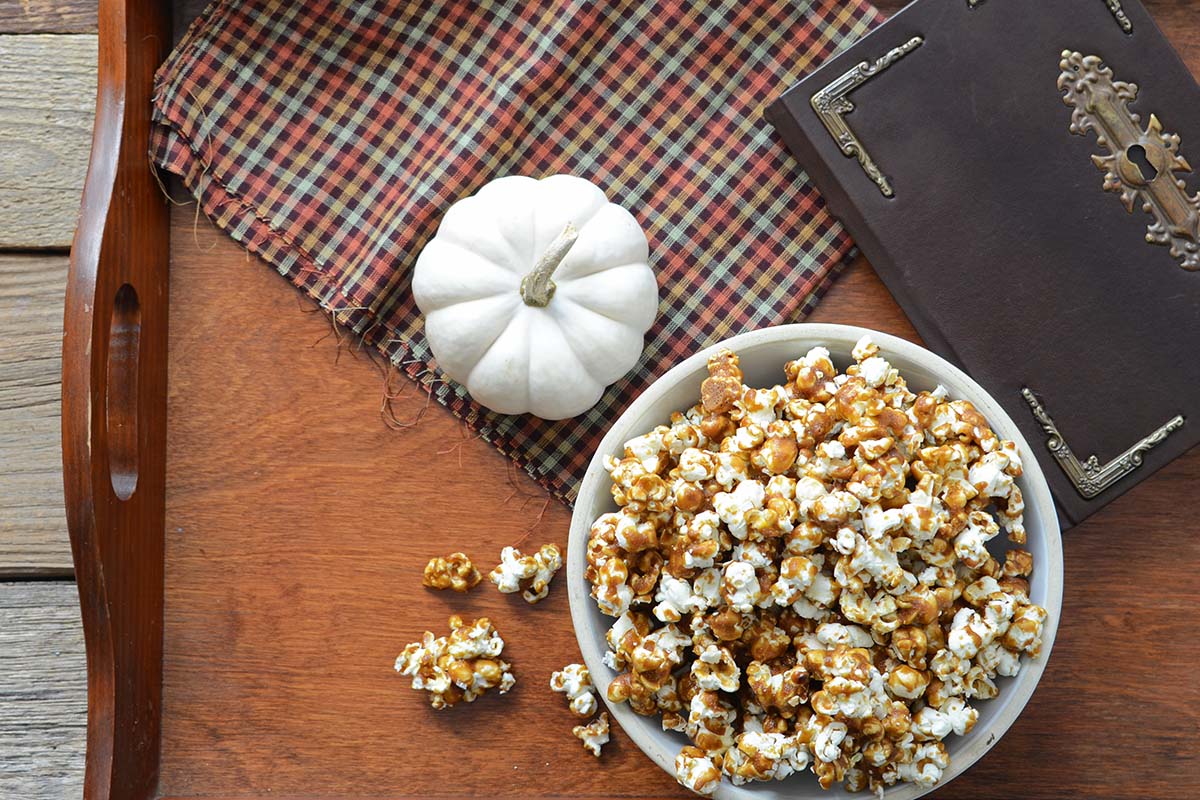 vintage book and bowl of butterbeer popcorn on dark wood tray
