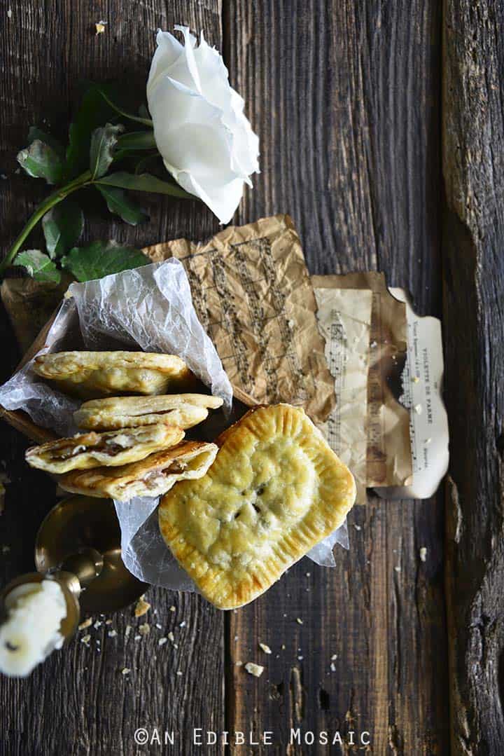 Apple Hand Pies with White Rose on Dark Wood Table