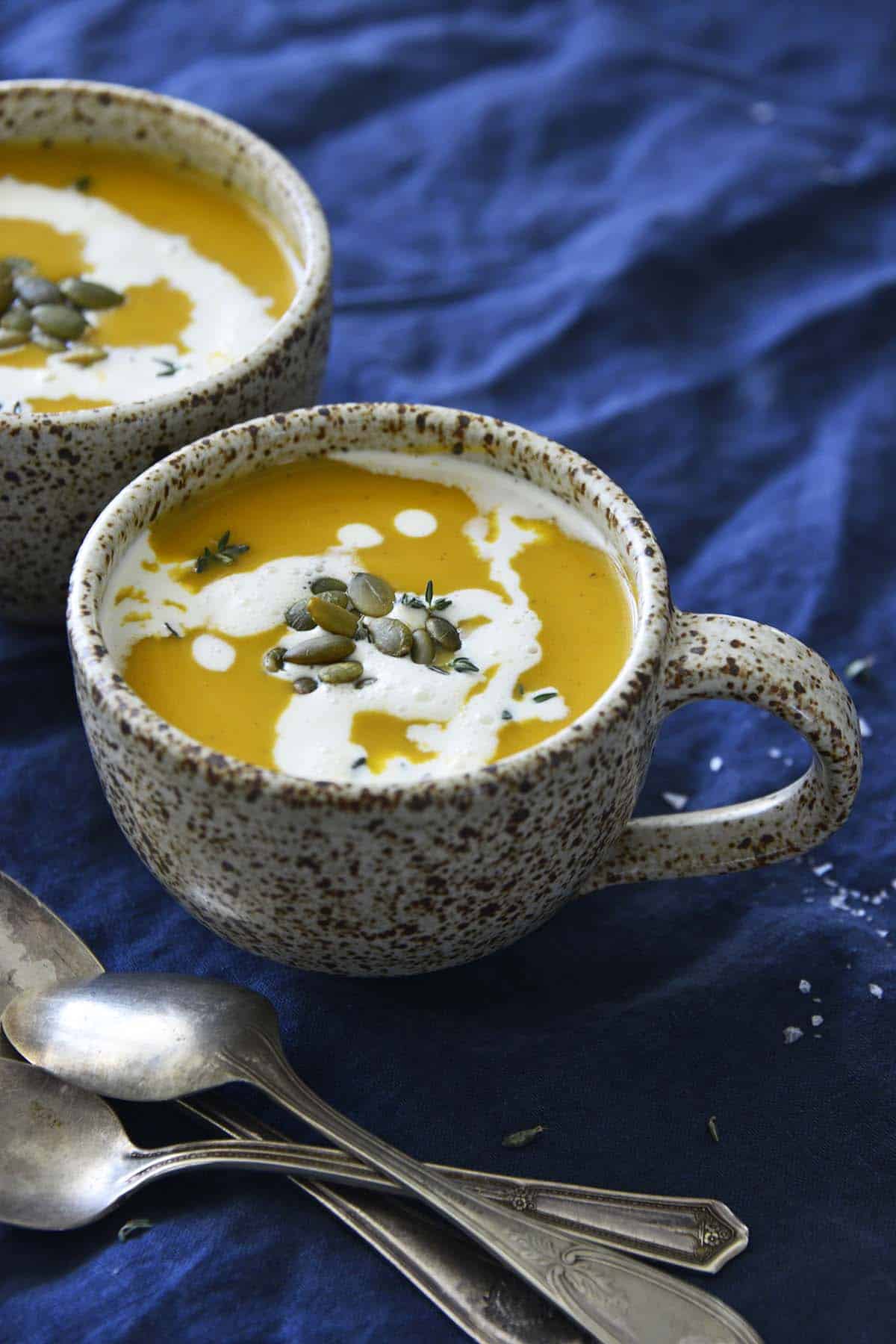 cozy instant pot butternut soup servings on blue tablecloth