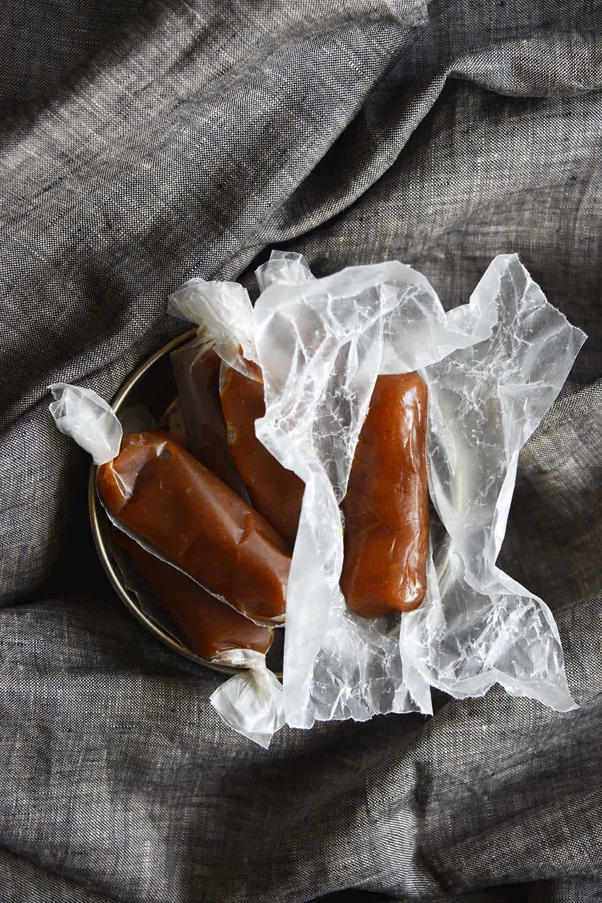 overhead view of unwrapped gingerbread caramel in candy bowl