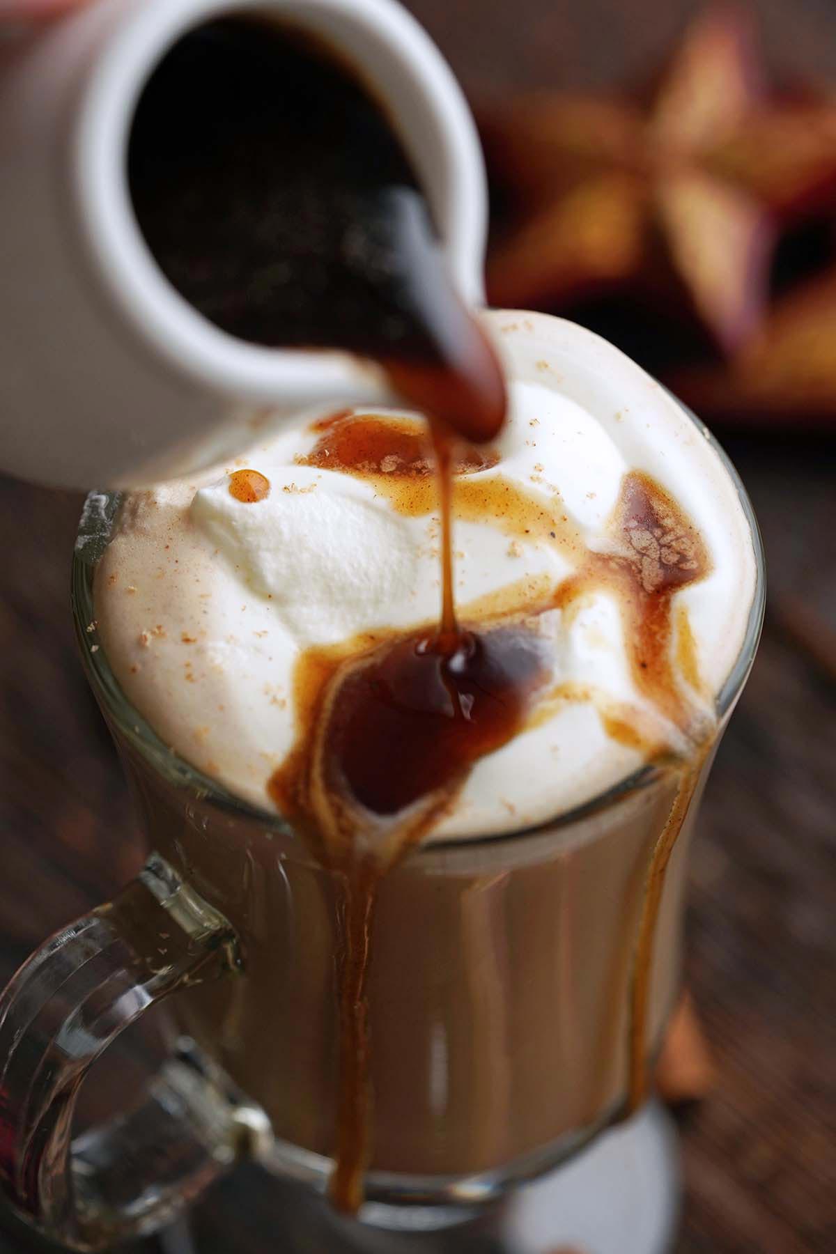 pouring gingerbread simple syrup onto homemade latte