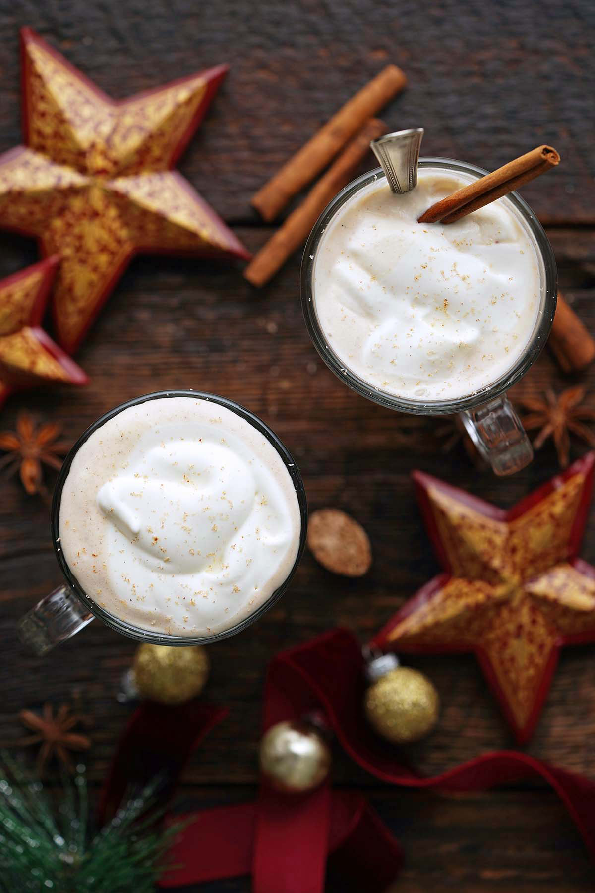 top view of homemade gingerbread lattes with festive decorations on rustic wooden table