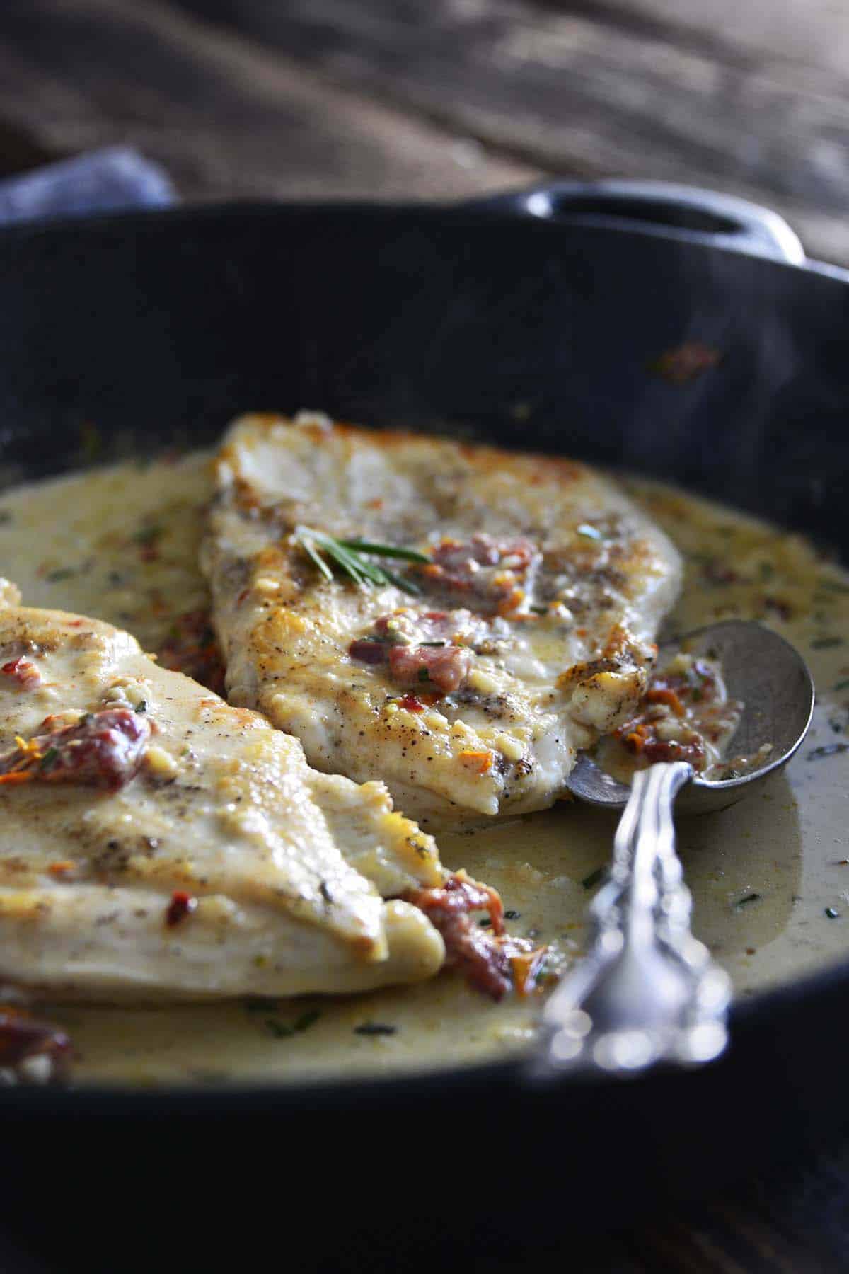 front view of creamy tuscan chicken cutlets in skillet