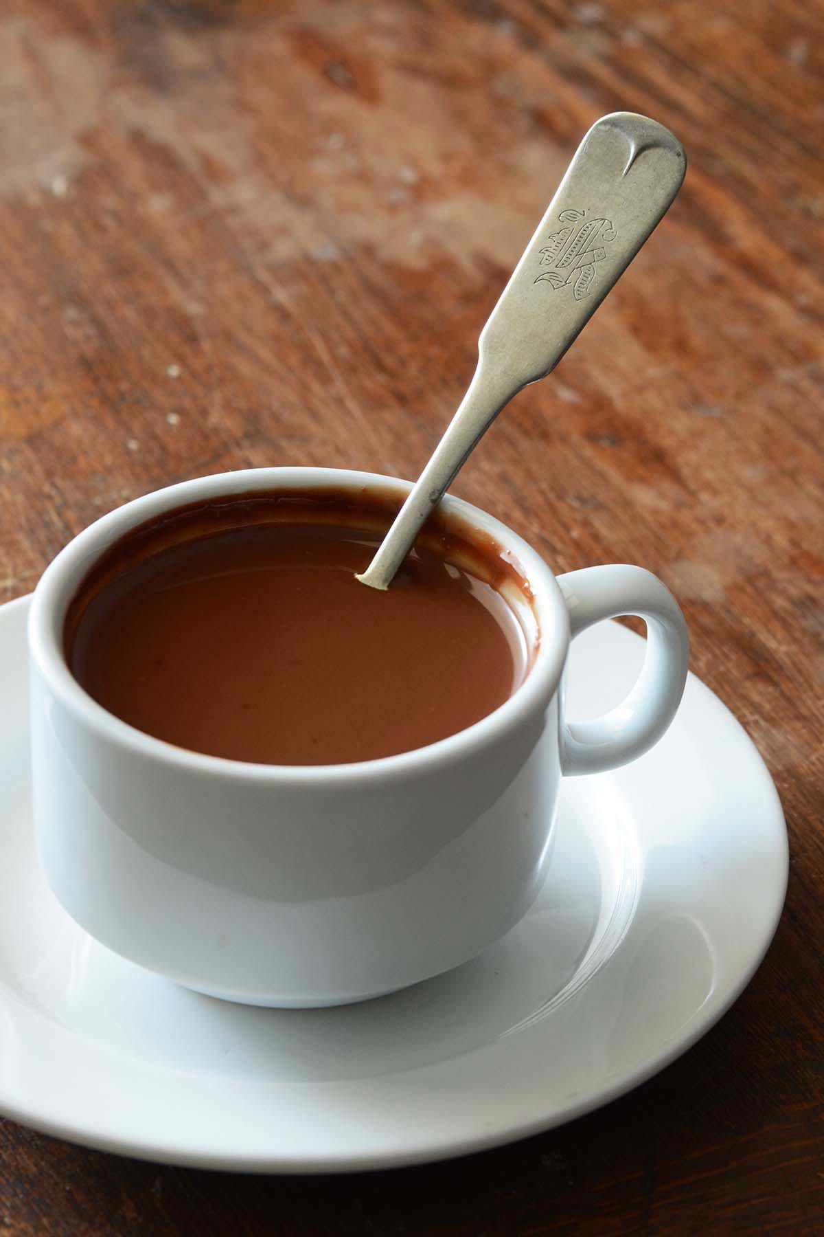 Parisian style drinking chocolate in white mug with vintage spoon