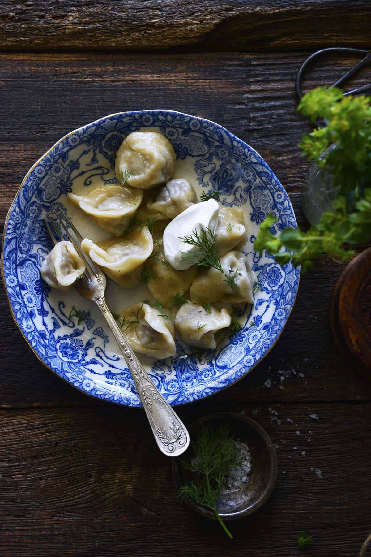 russian pelmeni dumplings with meat topped with sour cream