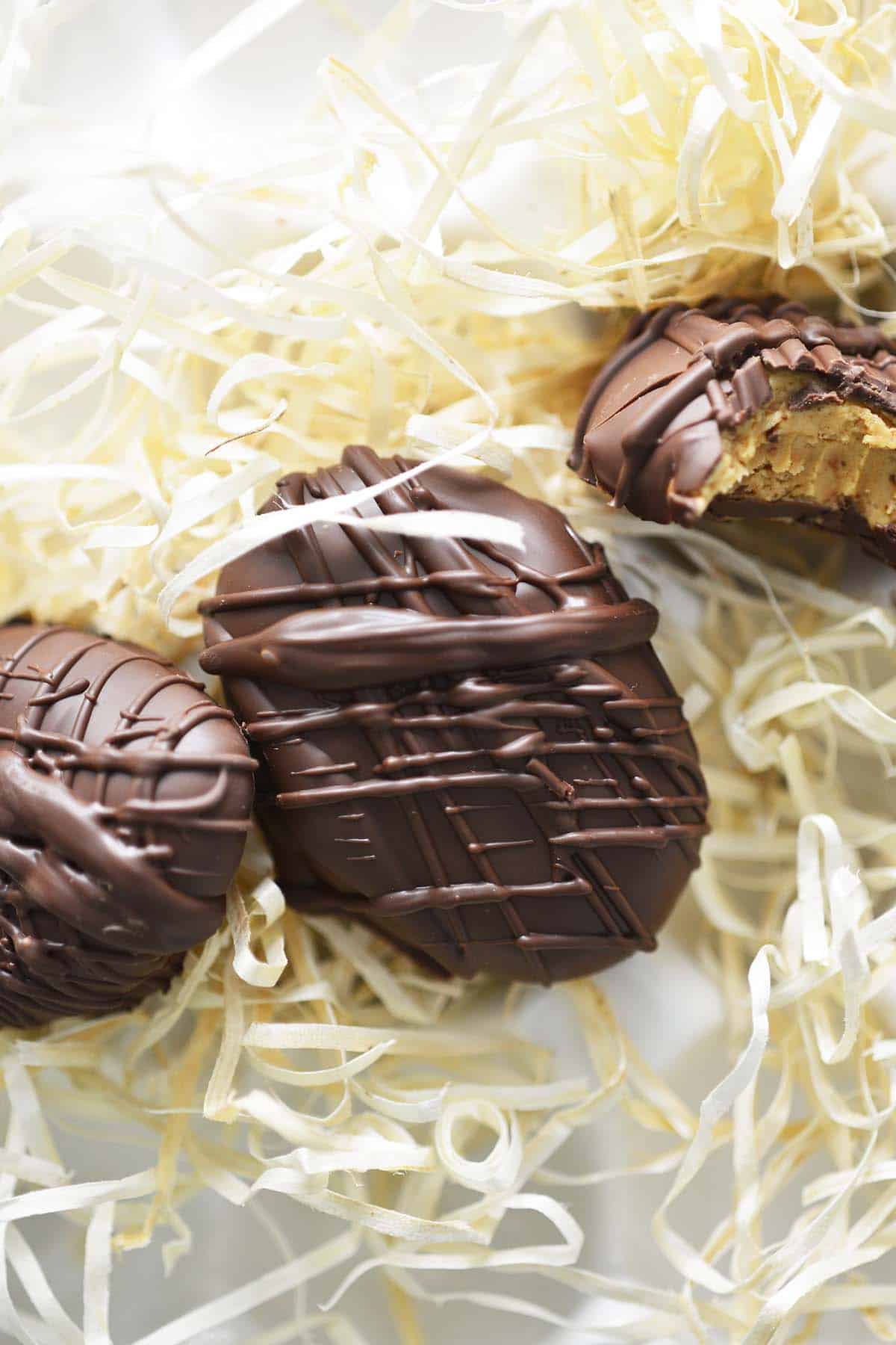 top view of chocolate coated peanut butter eggs on straw