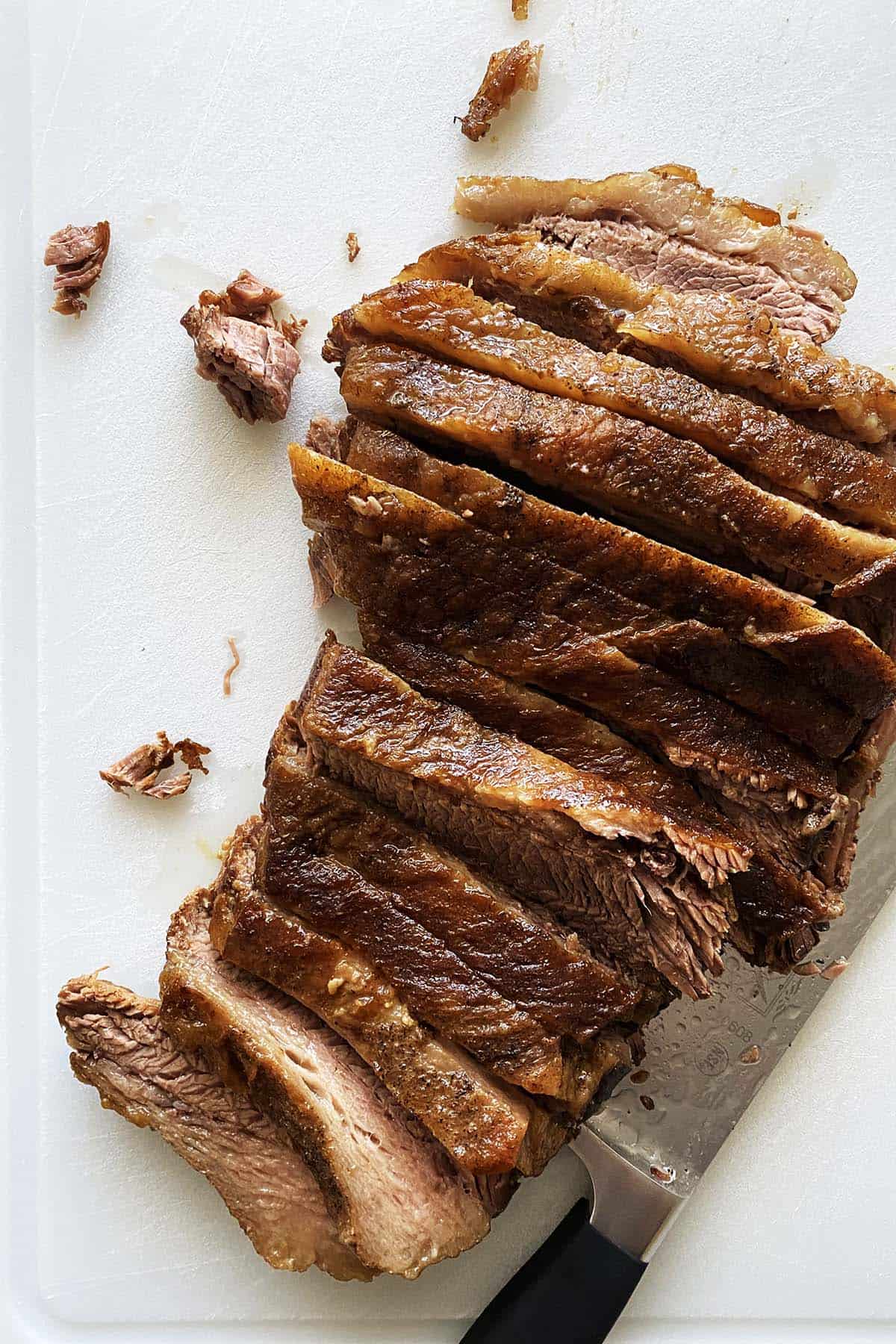 slicing beef brisket on cutting board