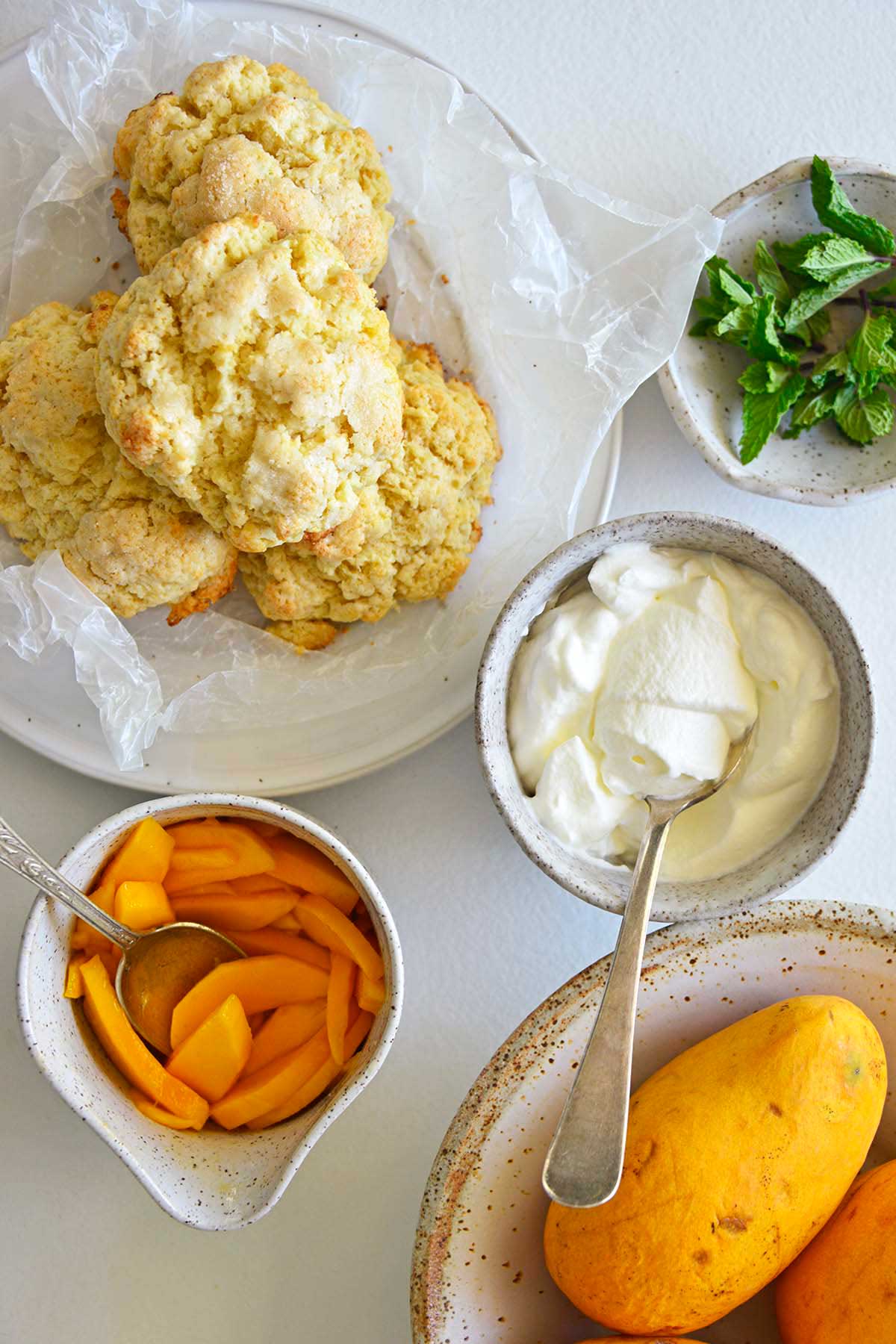 fixings for mango shortcake with flaky shortcake biscuits and whipped cream