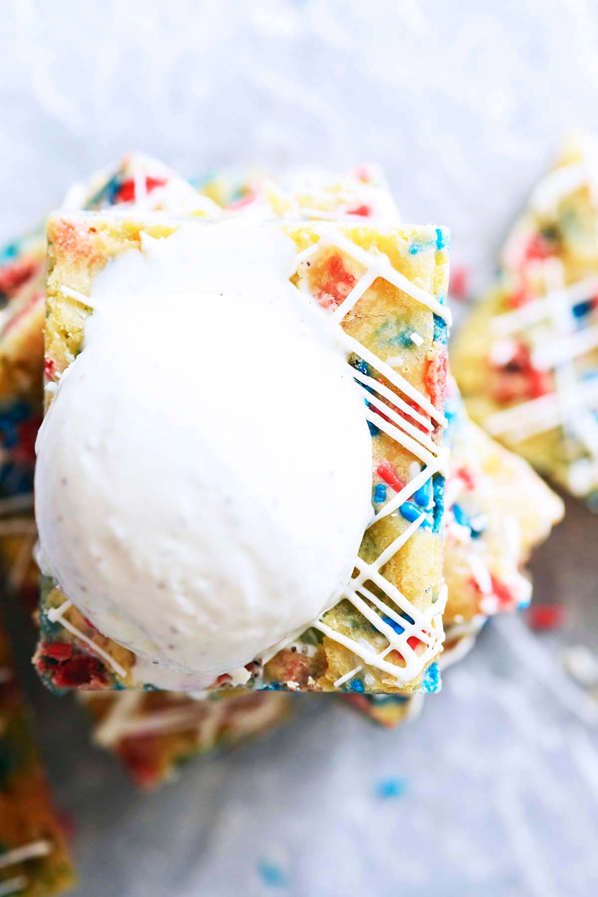 red white and blue funfetti blondie cookie bars with scoop of vanilla ice cream on top