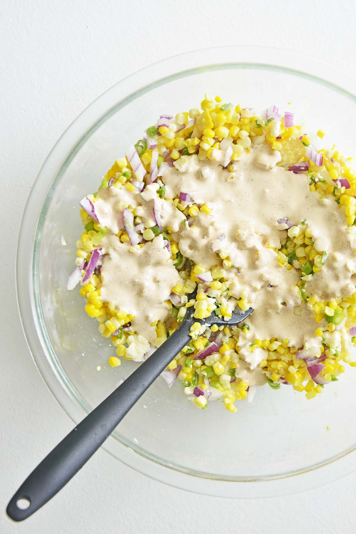 adding dressing to esquires corn salad