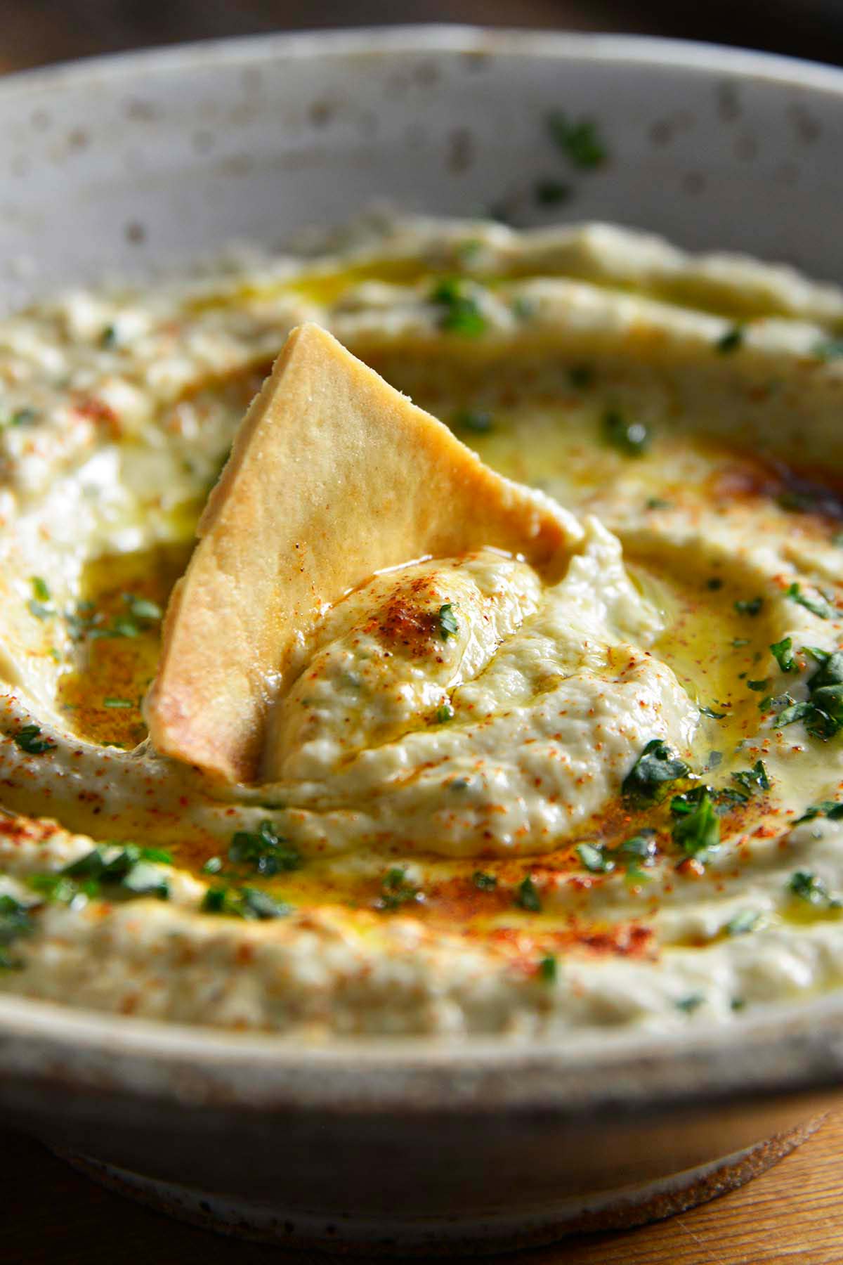 close up front view of toasted pita chip in creamy roasted eggplant dip