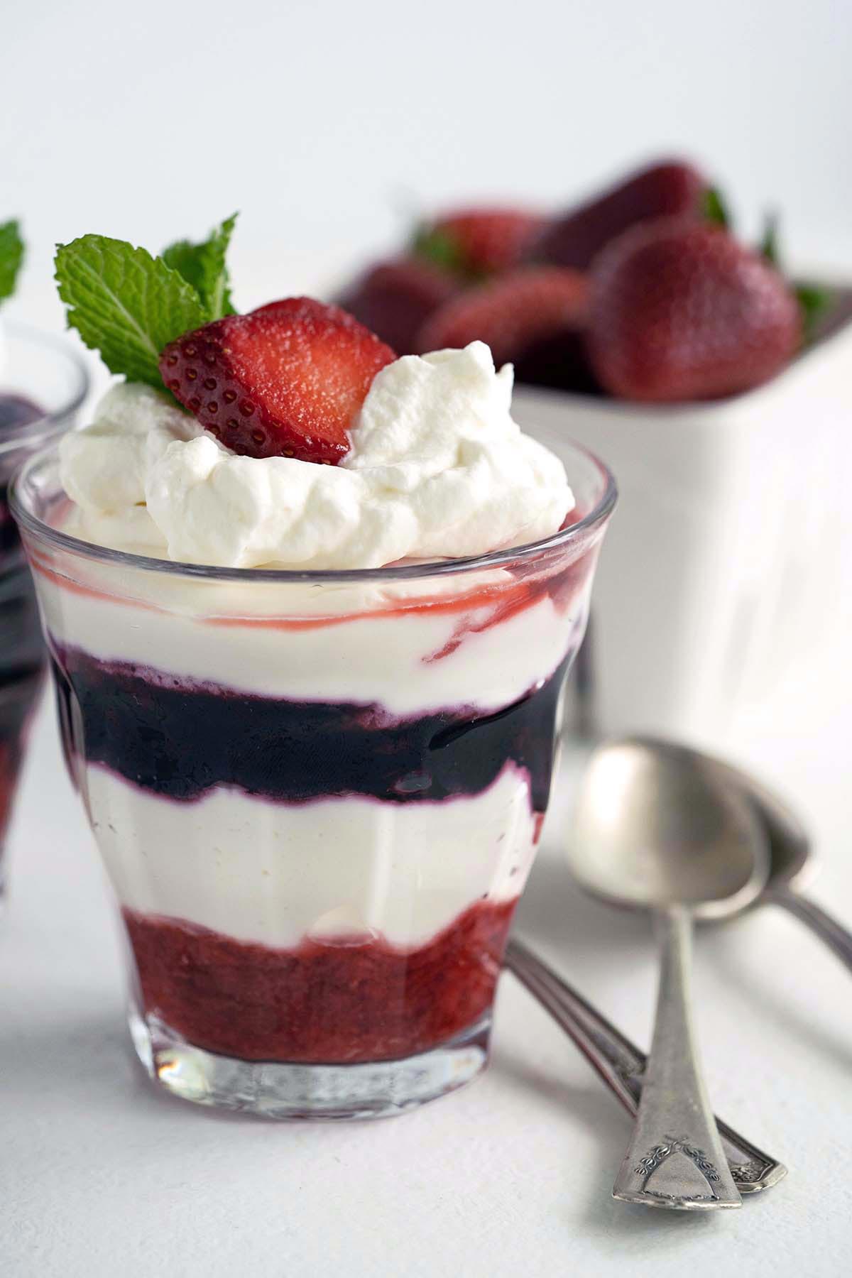 close up front view of cheesecake mousse berry parfaits with fresh strawberries