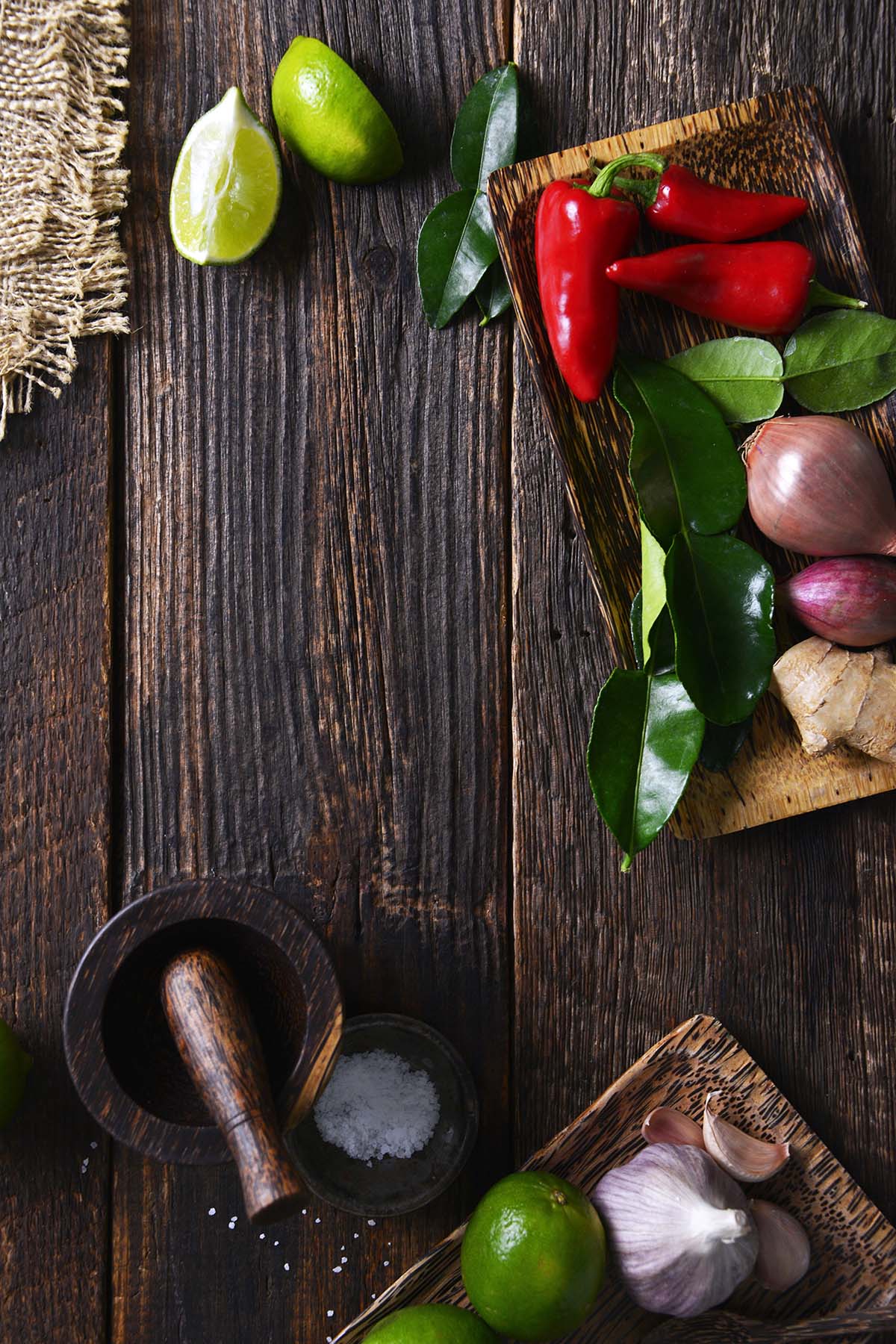 rustic dark wooden table with thai aromatics and teak wood