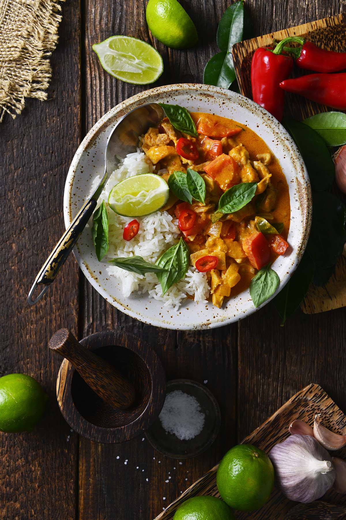 rustic dark wooden table with Thai aromatics teak wood and Panang Curry with chicken and rice
